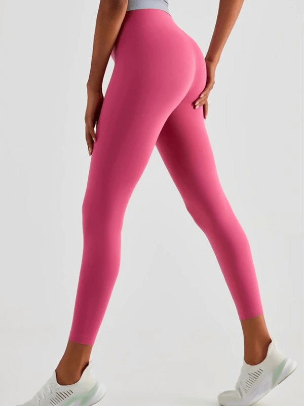 Model showcasing seamless breathable women's fitness leggings in vibrant pink, designed for yoga and workout comfort.